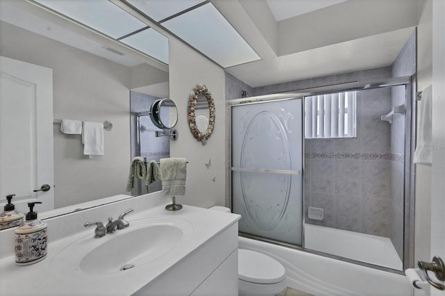 full bathroom with vanity, shower / bath combination with glass door, and toilet