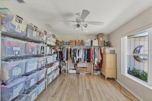 spacious closet with light hardwood / wood-style floors and ceiling fan