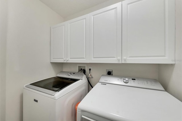 laundry room featuring cabinets and washer and dryer