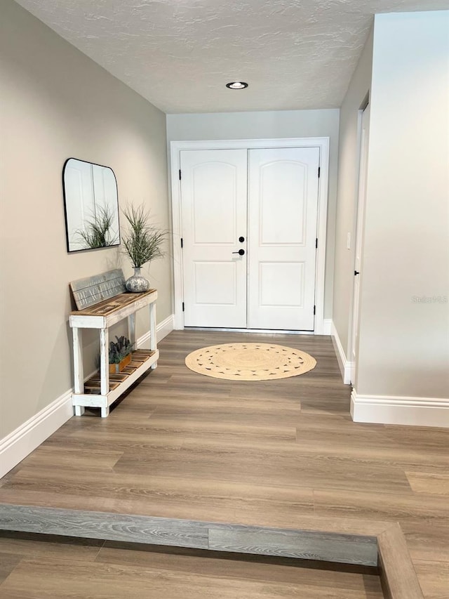 foyer entrance featuring hardwood / wood-style floors and a textured ceiling