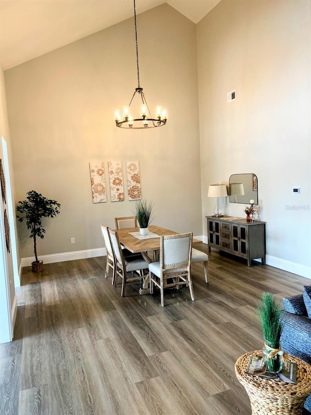 dining space featuring a chandelier, dark hardwood / wood-style floors, and high vaulted ceiling