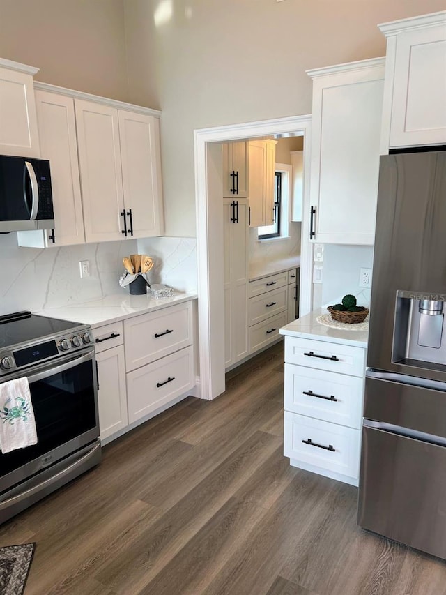 kitchen featuring white cabinets, appliances with stainless steel finishes, and dark hardwood / wood-style flooring