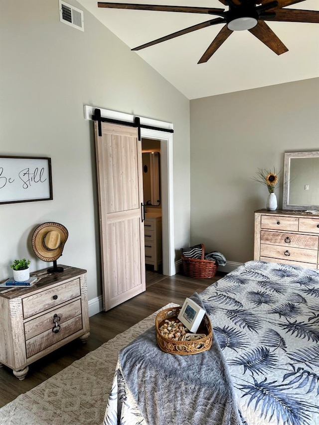 bedroom with dark wood-type flooring, vaulted ceiling, ceiling fan, and a barn door