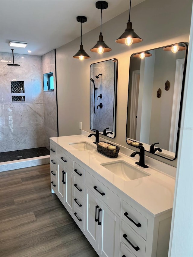 bathroom featuring vanity, hardwood / wood-style flooring, and a tile shower