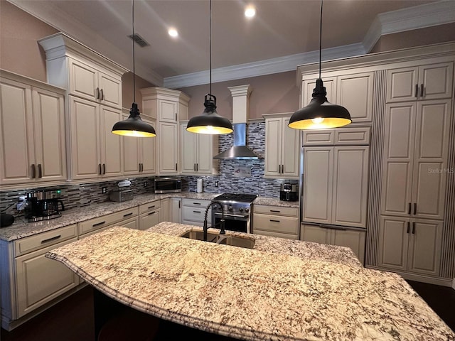 kitchen with sink, high end stove, hanging light fixtures, and light stone countertops