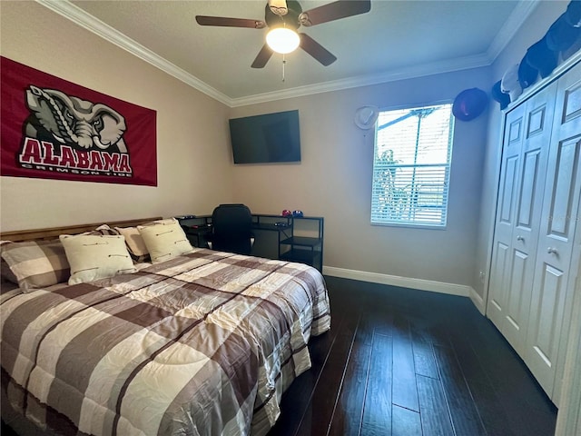 bedroom with dark wood-type flooring, a closet, ceiling fan, and ornamental molding