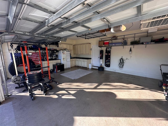 garage featuring white fridge with ice dispenser and a garage door opener