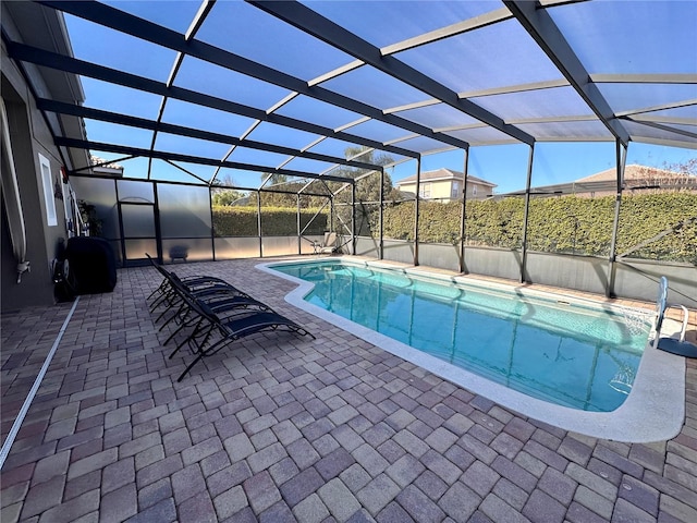 view of pool with a patio and glass enclosure