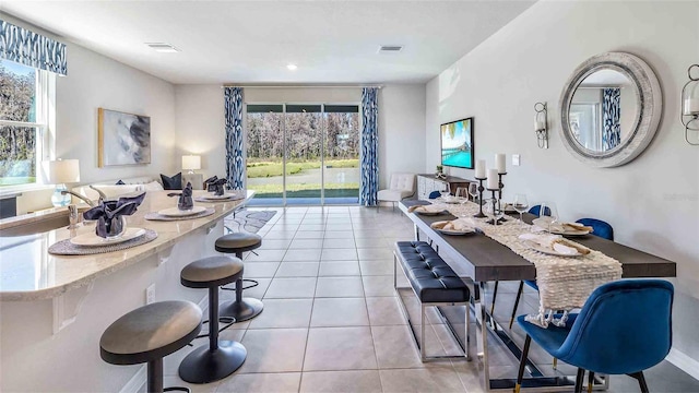 dining area with light tile patterned flooring and a wealth of natural light