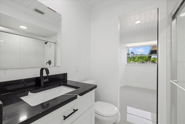 bathroom featuring vanity, toilet, crown molding, and an enclosed shower