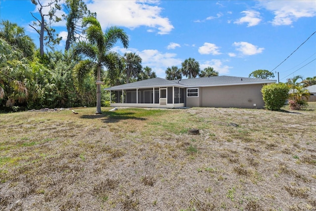 back of house with a sunroom and a lawn