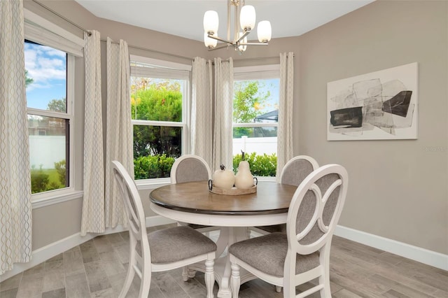 dining area with light hardwood / wood-style flooring and a notable chandelier