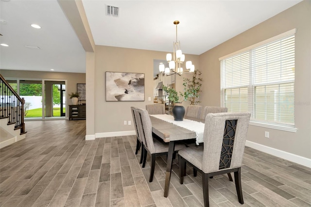 dining room with hardwood / wood-style floors and a chandelier