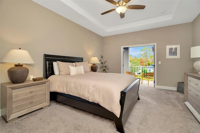 bedroom with access to outside, light colored carpet, a raised ceiling, and ceiling fan