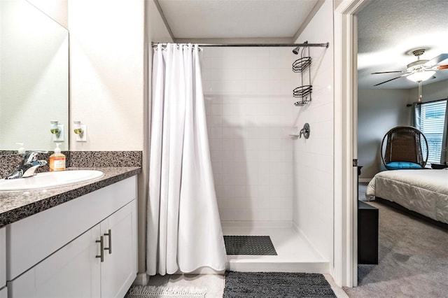 bathroom with vanity, ceiling fan, a textured ceiling, and a shower with curtain