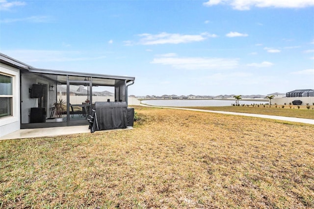 view of yard featuring a water view and a sunroom