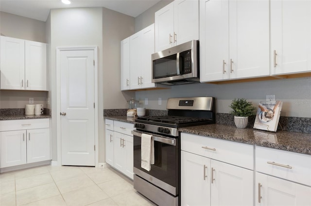 9805 Lemon Drop Loop, Sun City Center, FL 33573 - kitchen featuring stainless steel appliances, white cabinets, dark stone counters, light tile patterned flooring, and recessed lighting
