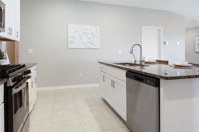 9805 Lemon Drop Loop, Sun City Center, FL 33573 - kitchen with appliances with stainless steel finishes, a sink, dark stone countertops, an island with sink, and white cabinetry