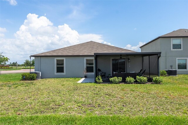 9805 Lemon Drop Loop, Sun City Center, FL 33573 - rear view of house featuring central air condition unit, a lawn, and stucco siding