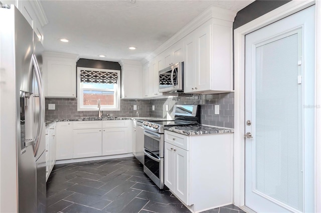 kitchen with sink, stainless steel appliances, white cabinetry, and tasteful backsplash