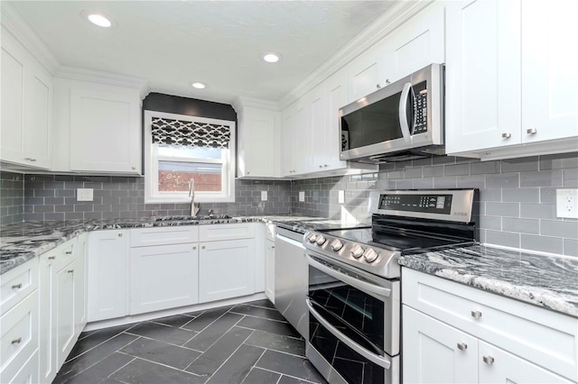 kitchen with white cabinets, sink, backsplash, stainless steel appliances, and stone countertops