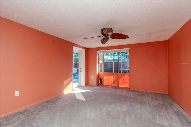 carpeted empty room featuring a textured ceiling and ceiling fan