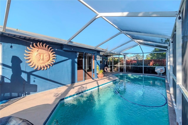 view of swimming pool with glass enclosure and a patio