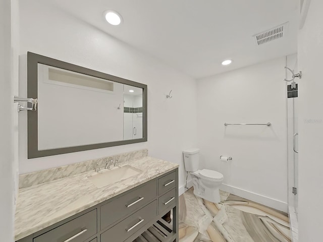 bathroom featuring vanity, toilet, and a shower with door