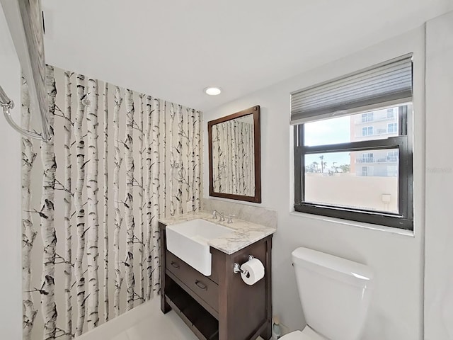 bathroom featuring vanity, walk in shower, and toilet