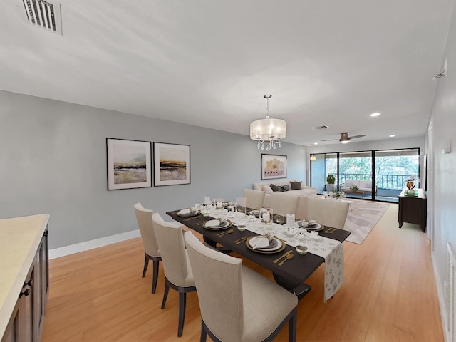 dining space with a notable chandelier and light hardwood / wood-style floors