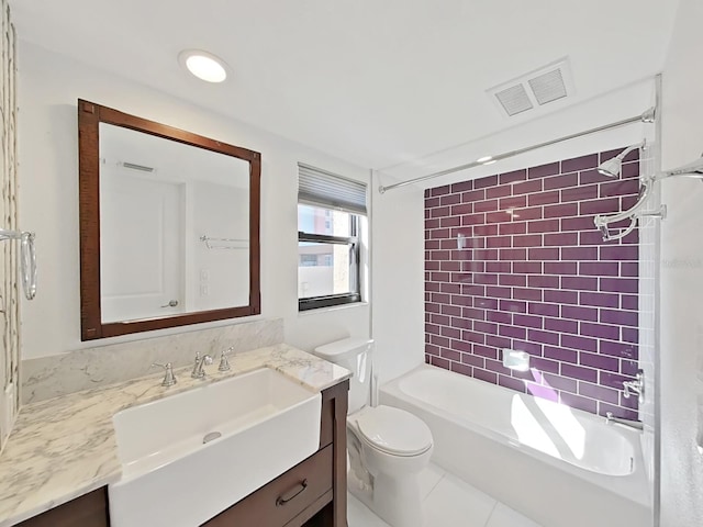 full bathroom with tiled shower / bath, vanity, tile patterned floors, and toilet