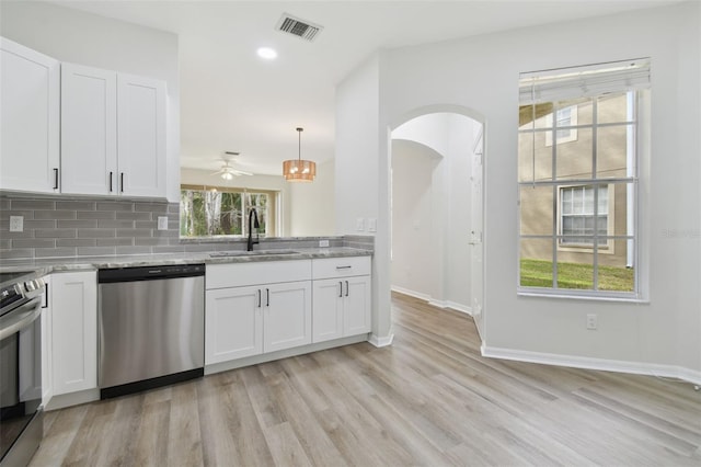 kitchen with white cabinetry, stainless steel appliances, decorative light fixtures, and sink