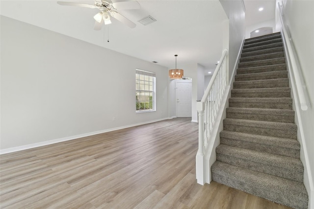 stairway featuring hardwood / wood-style flooring and ceiling fan