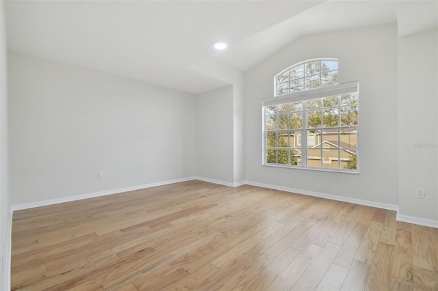 empty room featuring lofted ceiling and light wood-type flooring