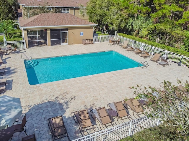 view of swimming pool with a patio area and a sunroom