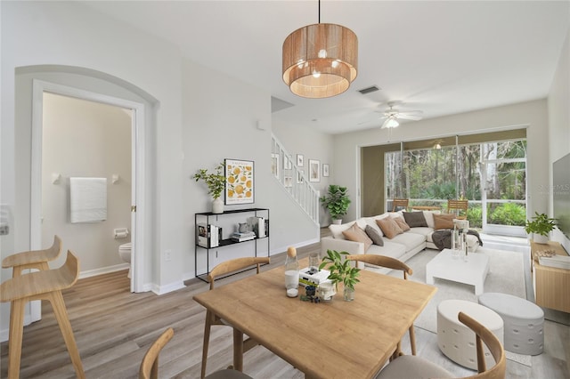 dining space with ceiling fan, radiator, and light wood-type flooring