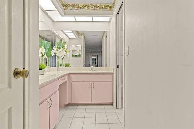 bathroom featuring vanity, a skylight, and tile patterned flooring