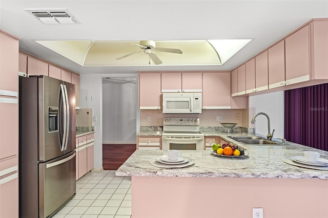 kitchen featuring sink, white appliances, kitchen peninsula, and light tile patterned floors