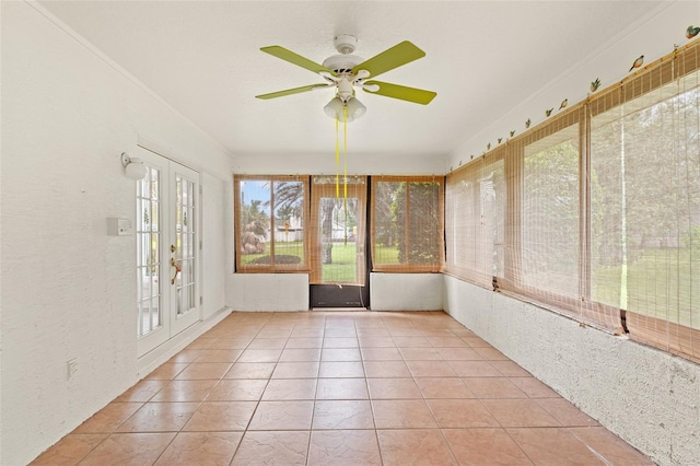 unfurnished sunroom featuring ceiling fan and french doors