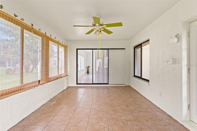 unfurnished sunroom with ceiling fan