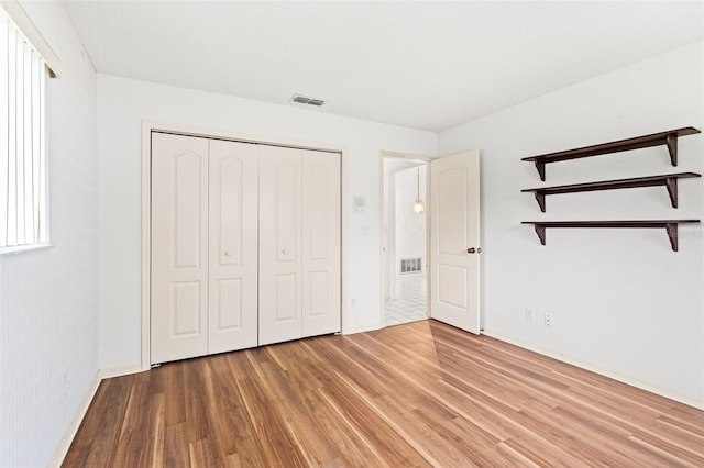 unfurnished bedroom featuring a closet and hardwood / wood-style flooring