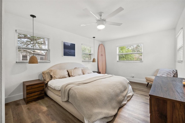 bedroom with dark hardwood / wood-style floors and ceiling fan