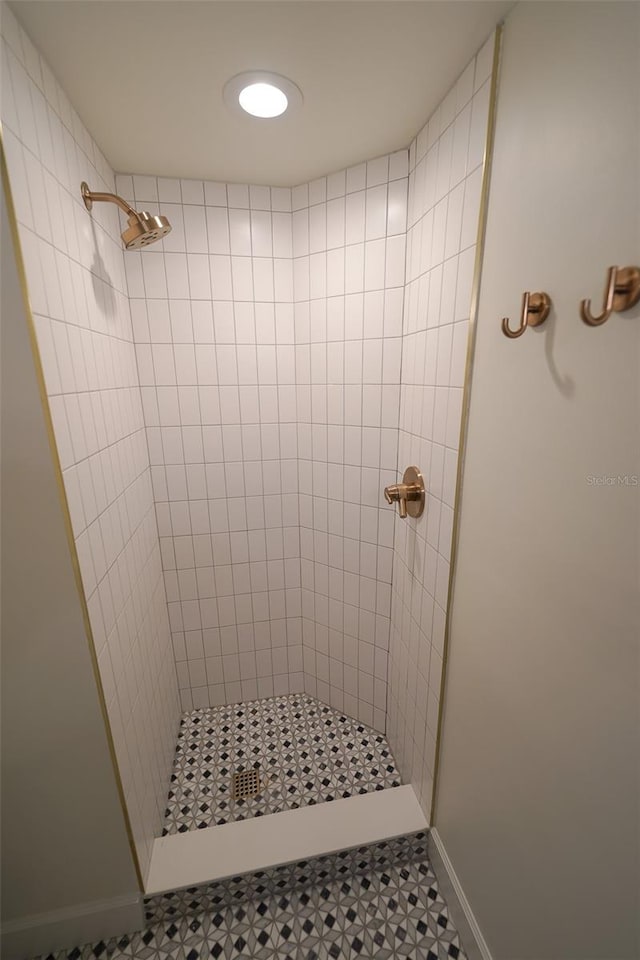 bathroom with a tile shower and tile patterned floors