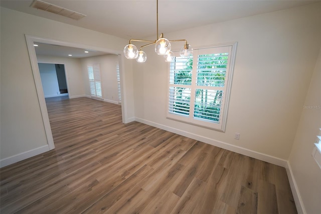 unfurnished dining area featuring hardwood / wood-style flooring and a chandelier