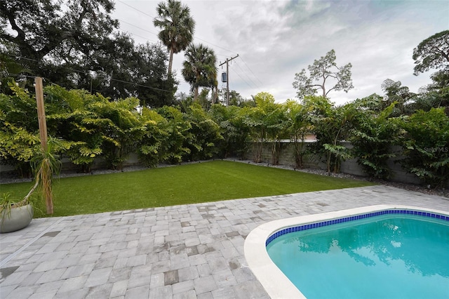 view of swimming pool featuring a yard and a patio area