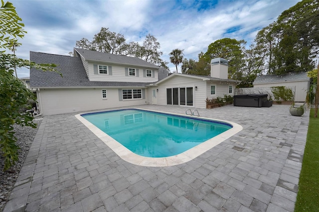 view of pool with a hot tub and a patio