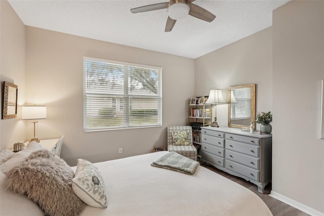 bedroom featuring ceiling fan, dark wood-type flooring, and a textured ceiling