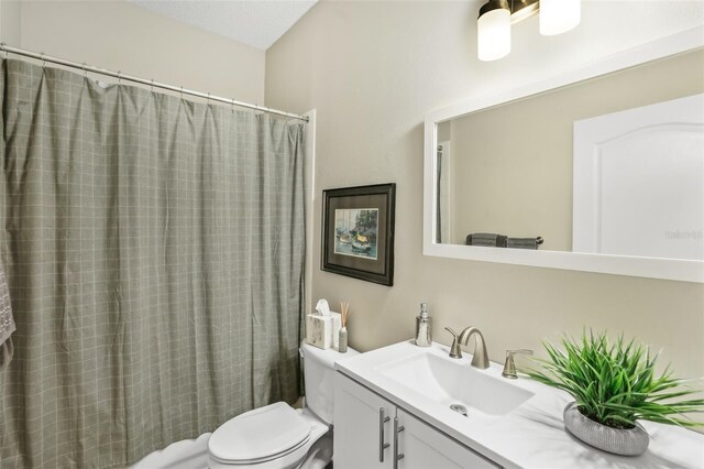 bathroom featuring vanity, toilet, and a shower with curtain