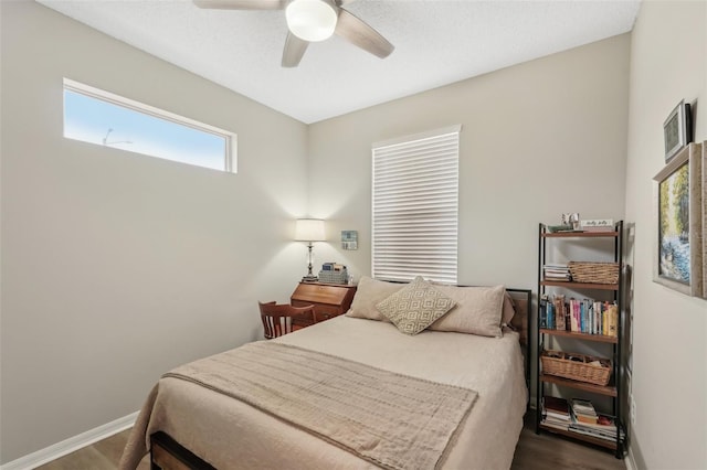 bedroom with dark hardwood / wood-style floors and ceiling fan