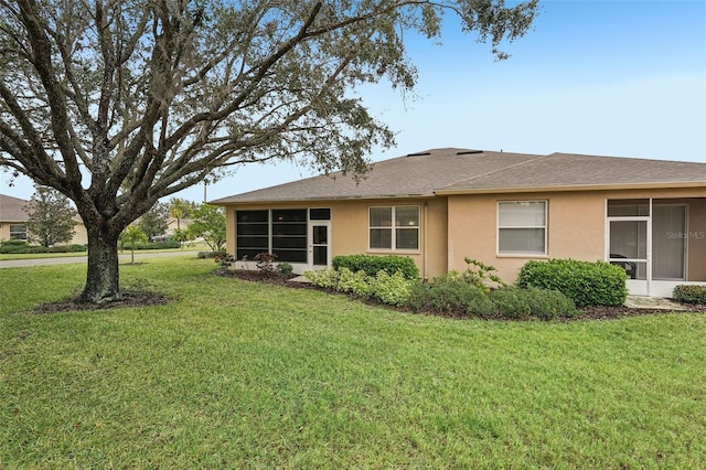 view of property exterior featuring a sunroom and a lawn